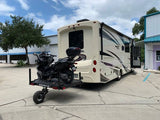 A motor scooter being transported on a Swivelwheel-46 scooter carrier system attached to the rear of an RV.